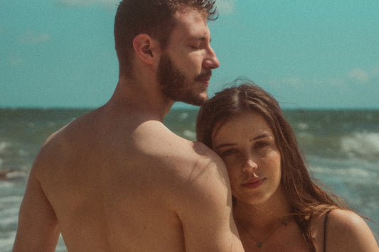 a man standing next to a woman on a beach