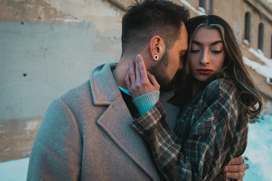 Couple embracing near a concrete wall in winter